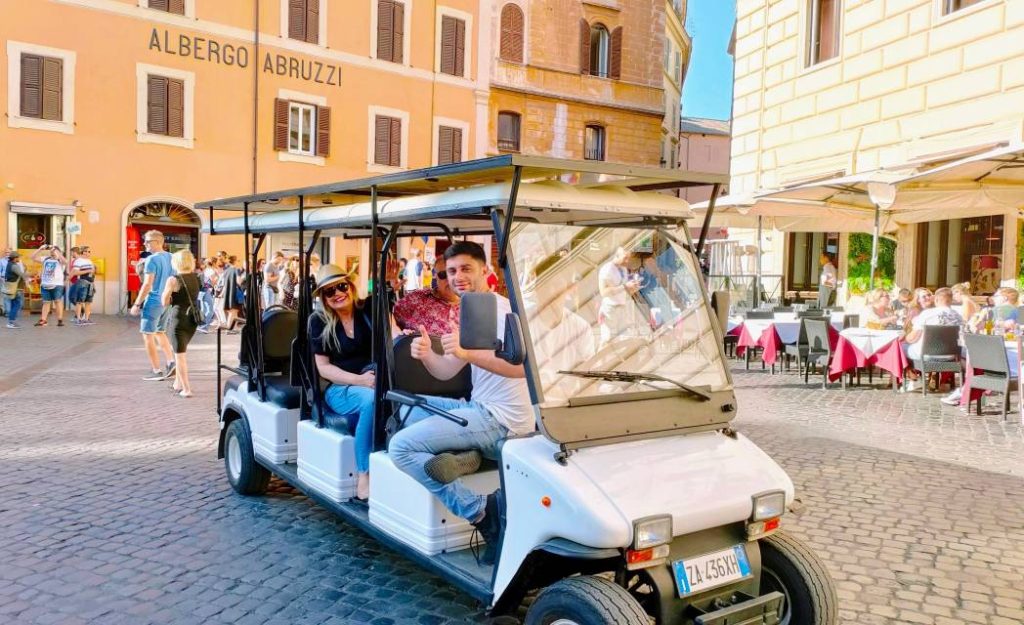 Family enjoying a private golf cart tour of Rome with iconic landmarks in the background